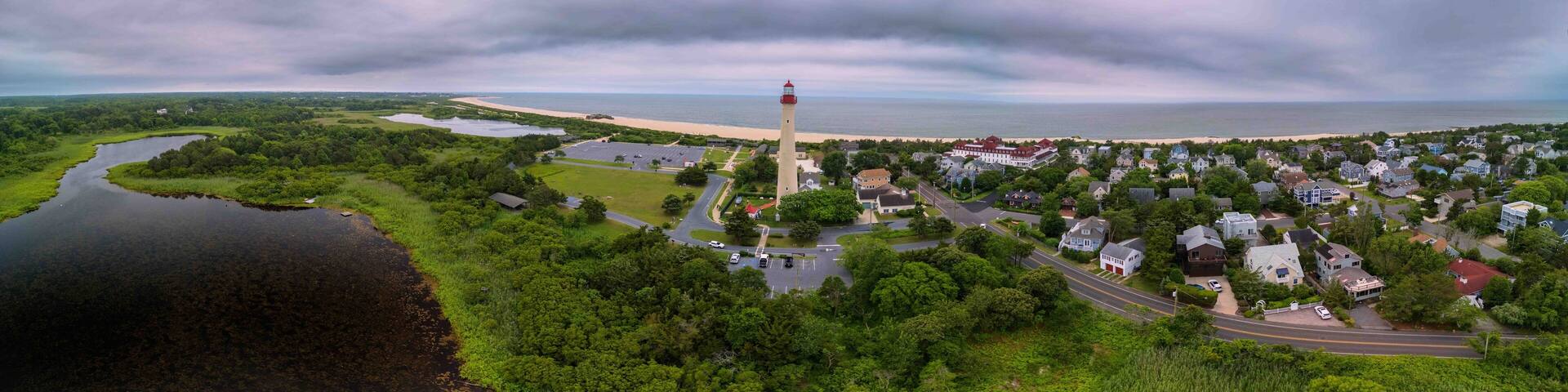 A coastal town with a prominent lighthouse, a river, and a residential area.