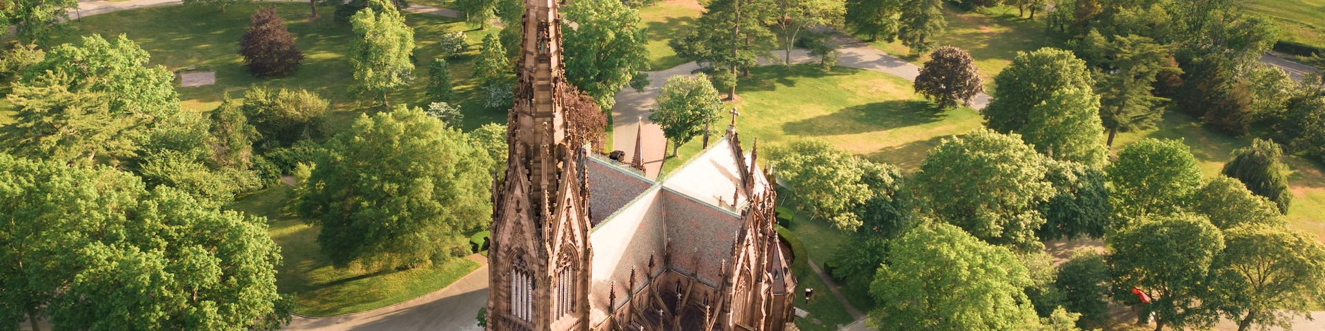 Vista aérea de una iglesia de estilo gótico rodeada de exuberante vegetación y un campo de golf.