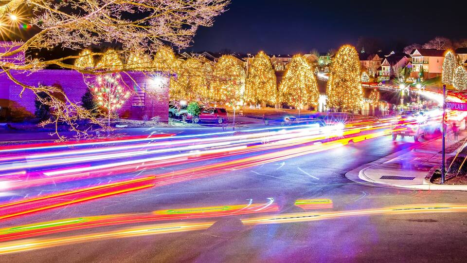 A brightly lit intersection with festive Christmas lights and decorations.