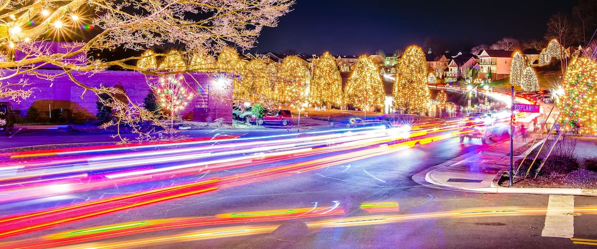 A brightly lit intersection with festive Christmas lights and decorations.