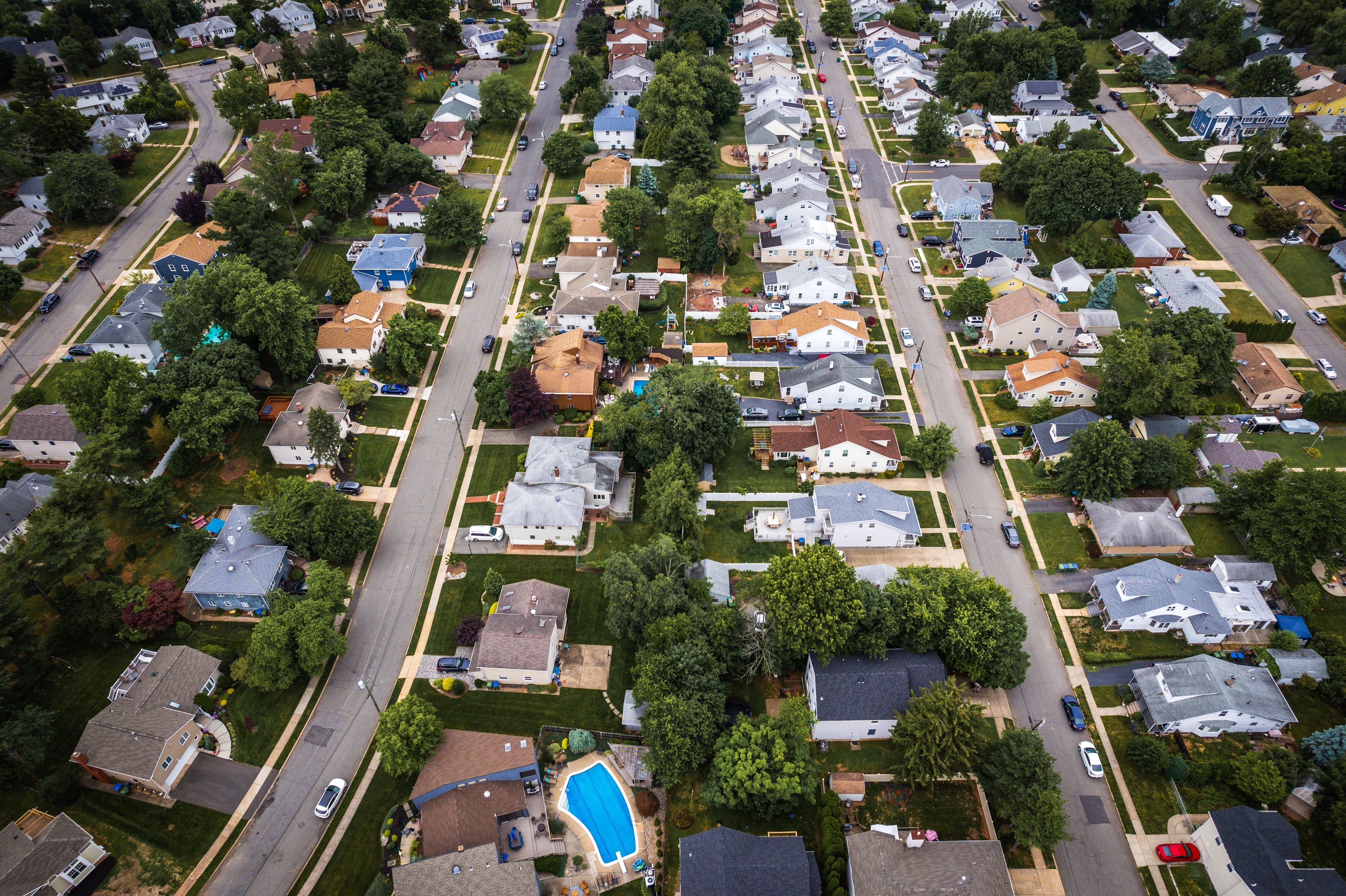 A residential neighborhood with houses, streets, and a swimming pool.