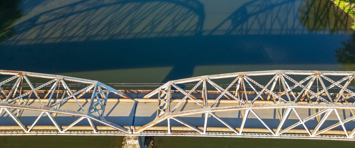 The reflection of the Tidioute Bridge on the Allegheny River as seen from above in Tidioute, Pennsylvania, USA on a sunny summer day