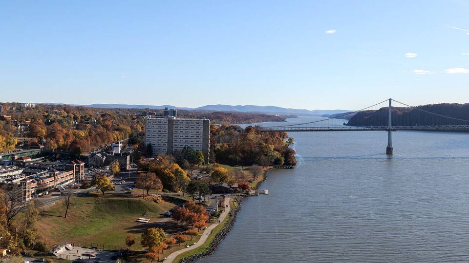 panoramic view of mid hudson bridge over hudson river valley (poughkeepsie, upstate new york) sunny day train station wide angle sun glare crossing suspension small town travel metro north