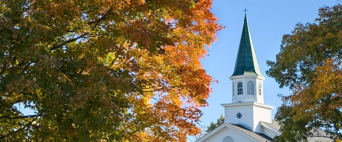 A church with a steeple and a sign that reads "Carmel United Methodist Church".