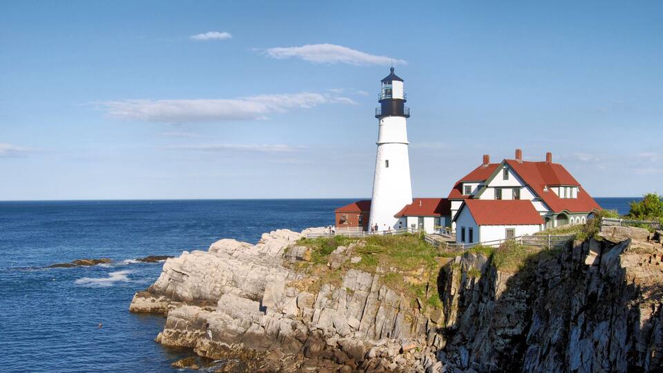 A lighthouse and a coastal house by the sea.