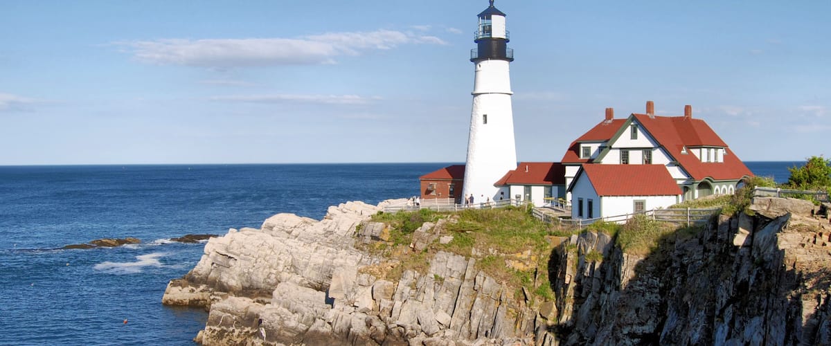 A lighthouse and a coastal house by the sea.