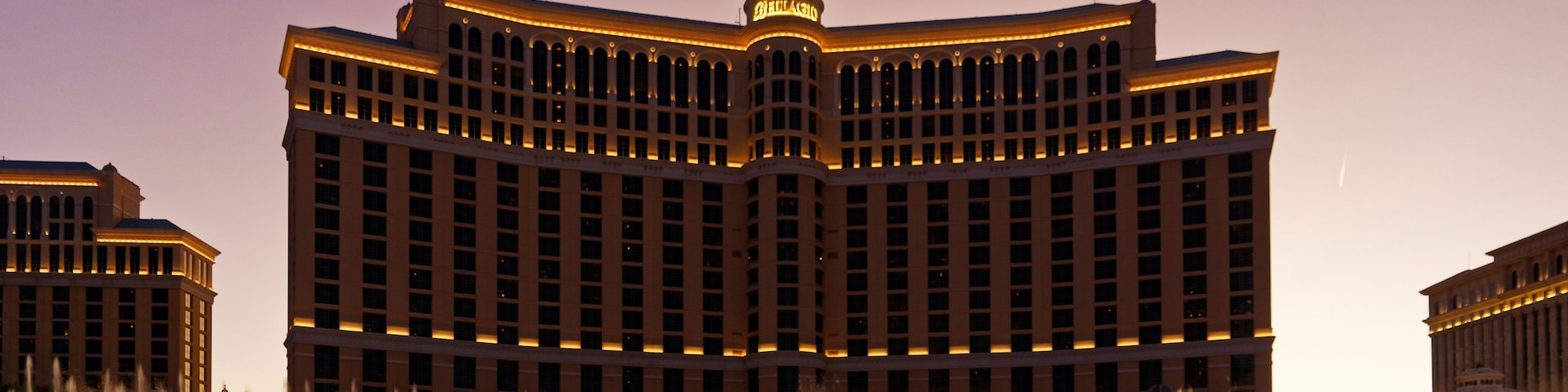 Un hotel grande con una fuente en la entrada.