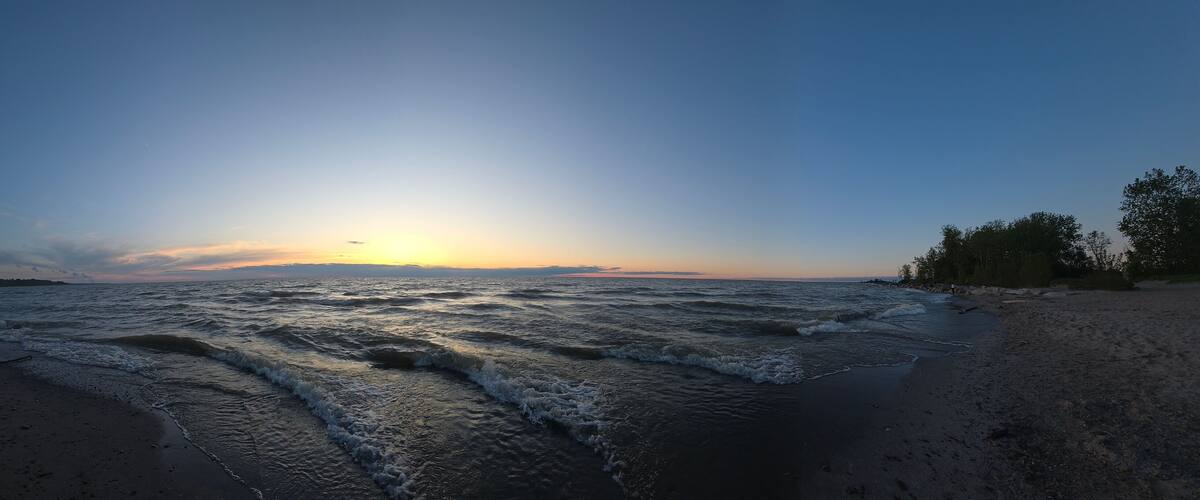 A beach with waves at sunset.