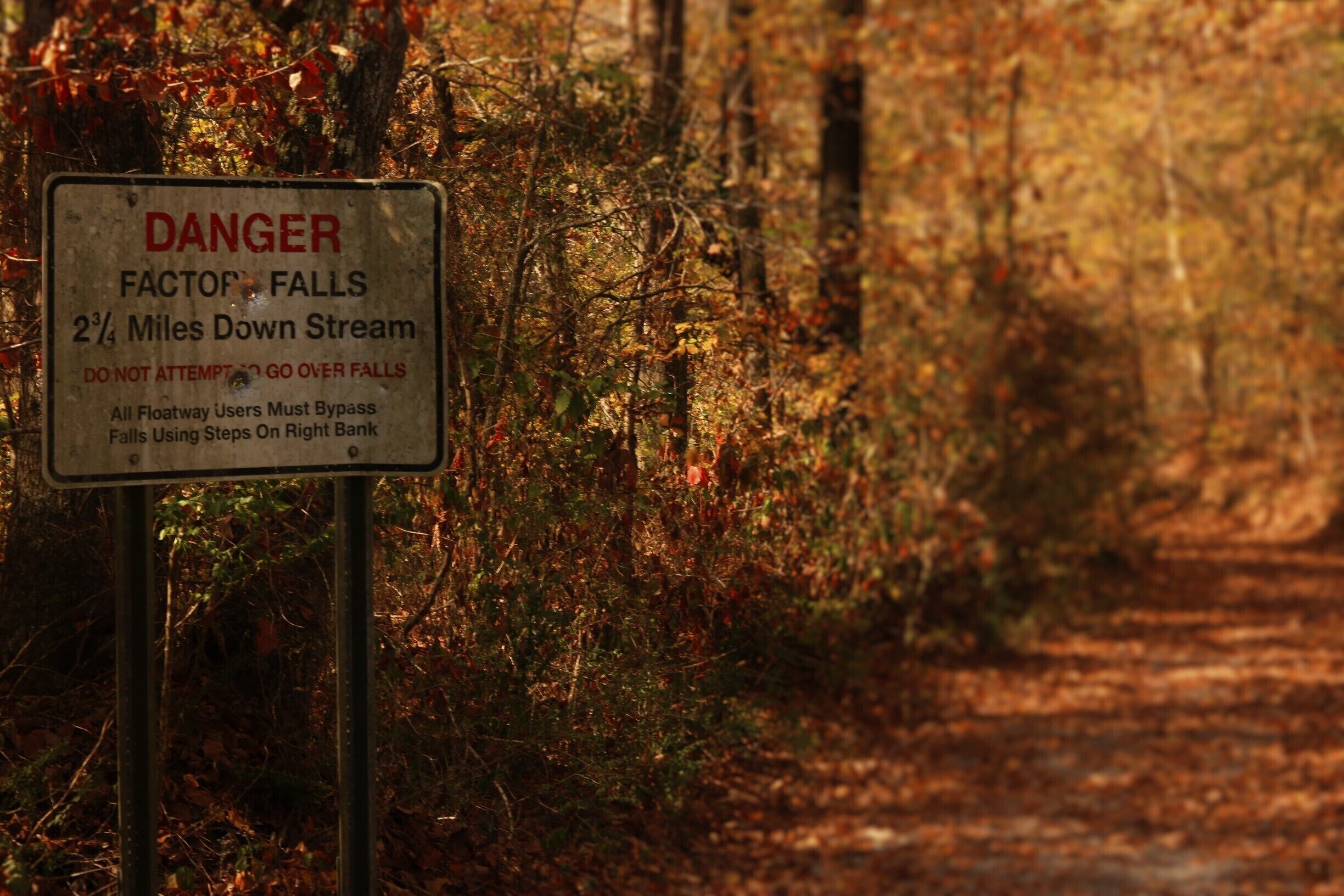 A warning sign about Factor Falls 2 3/4 miles down stream.