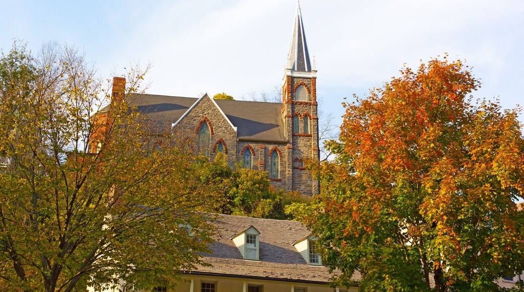 Historic city church in magnificent fall colors at Harpers Ferry, West Virginia, USA. The church on a hillside framed by maple trees.