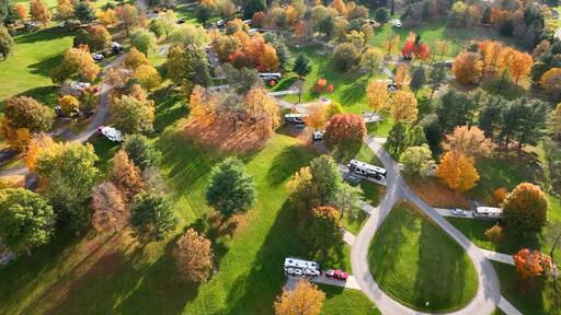 Campground with RVs and people camping outdoors in mountains of Pennsylvania during Autumn Fall season at Ives Run in Tioga
