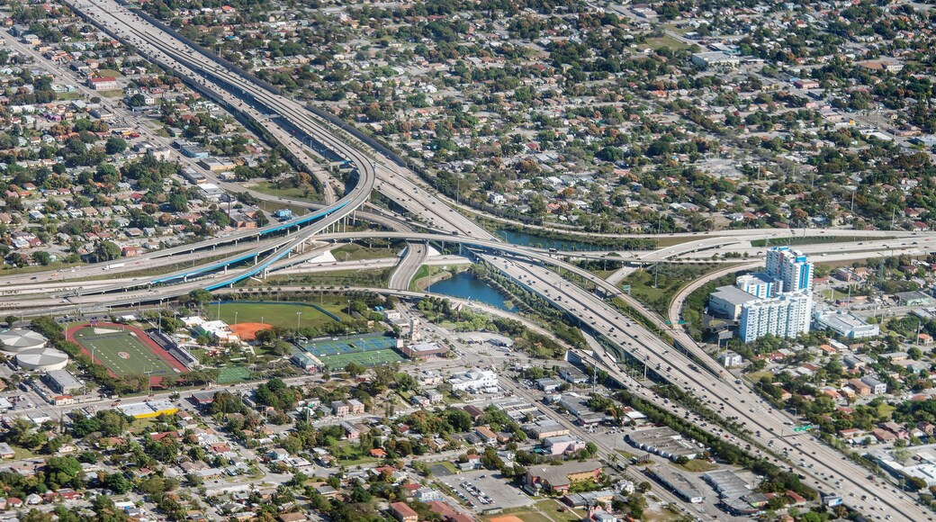 A complex highway interchange with multiple overpasses and a large body of water.