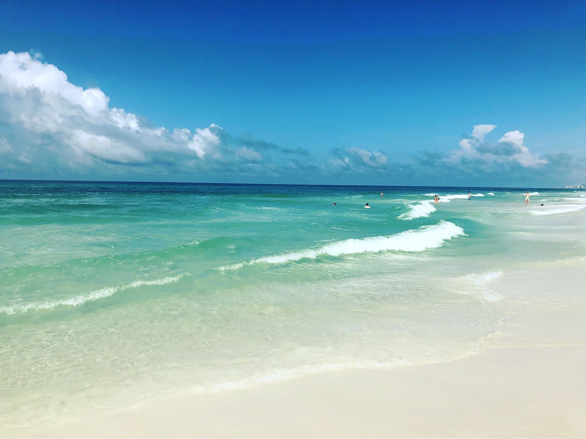 A beach with clear turquoise water and white sand.