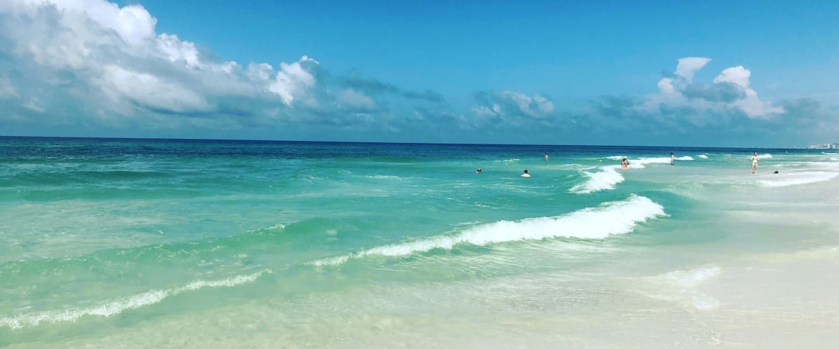 A beach with clear turquoise water and white sand.