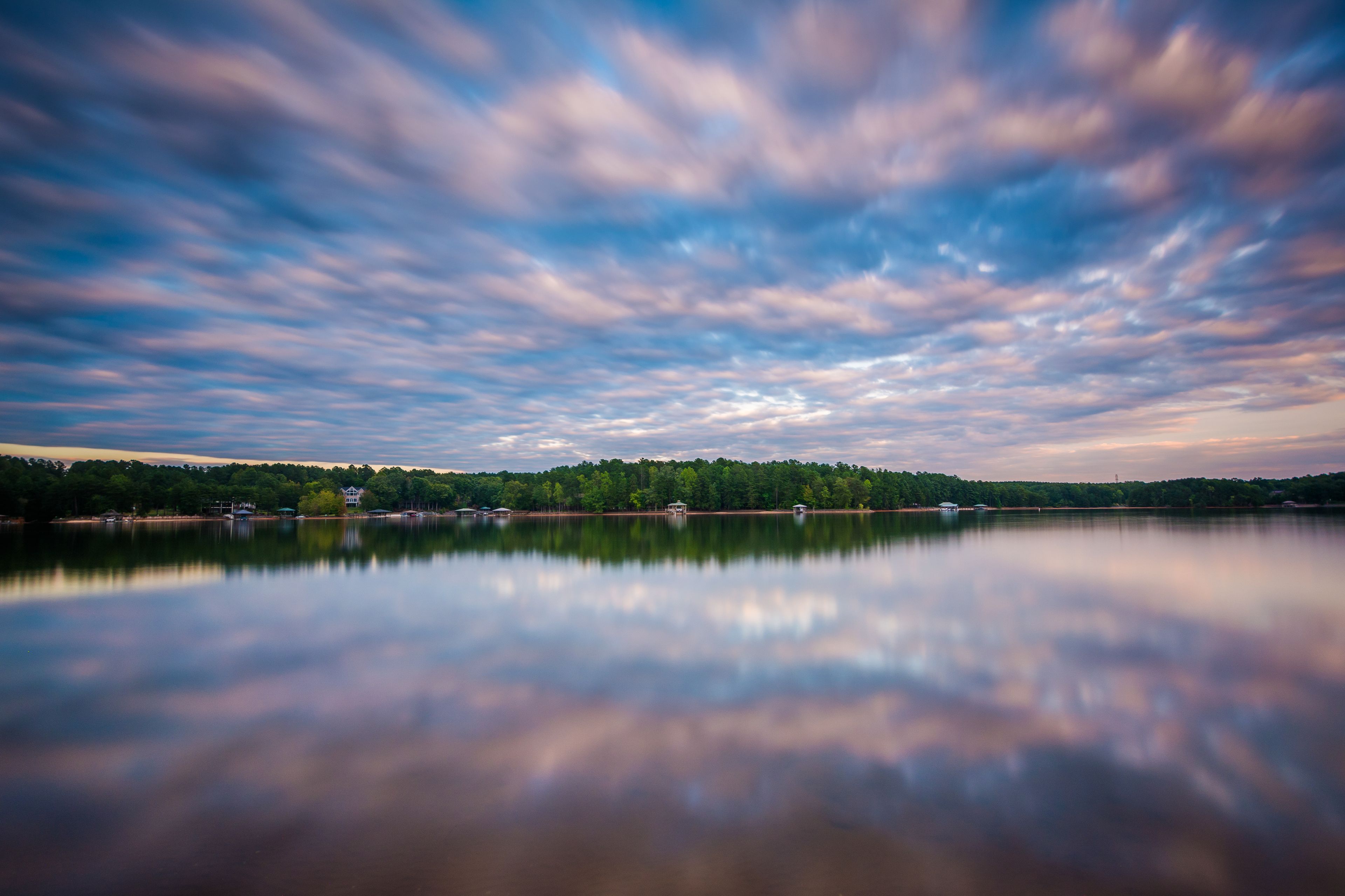 Un lago tranquilo que refleja el cielo y los árboles.