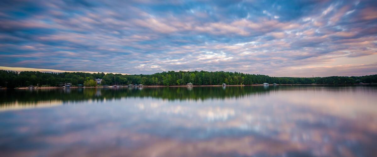 Un lago tranquilo que refleja el cielo y los árboles.