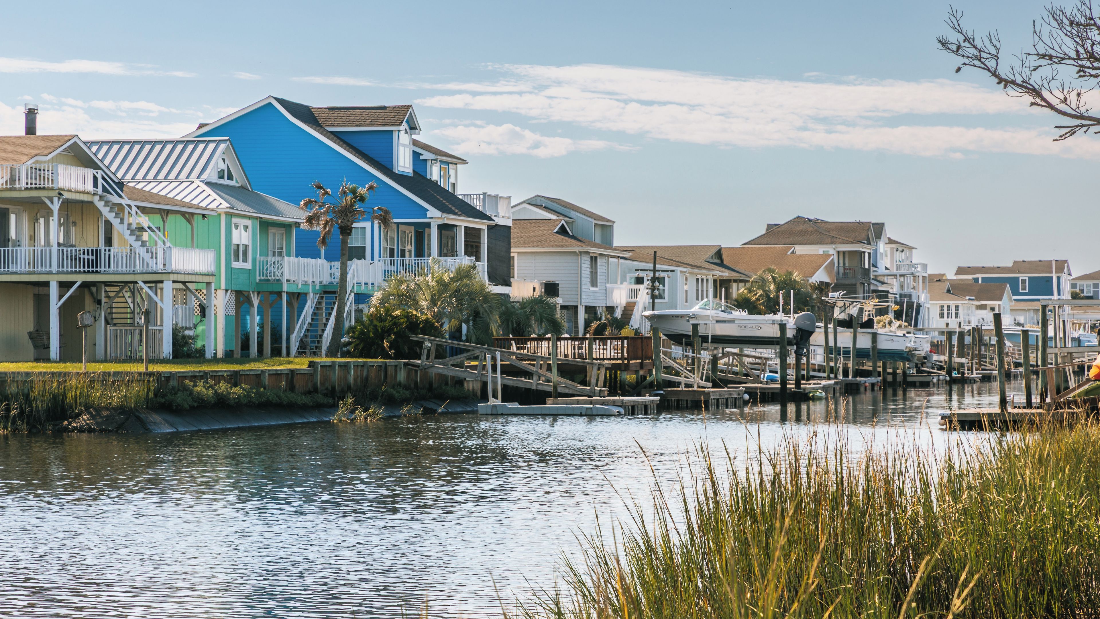 A waterfront community with colorful houses, a dock, and boats.
