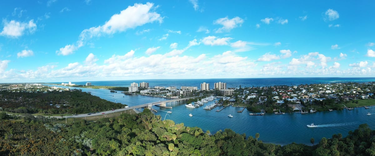 A coastal city with a marina, dense residential area, and a bridge connecting two land masses.