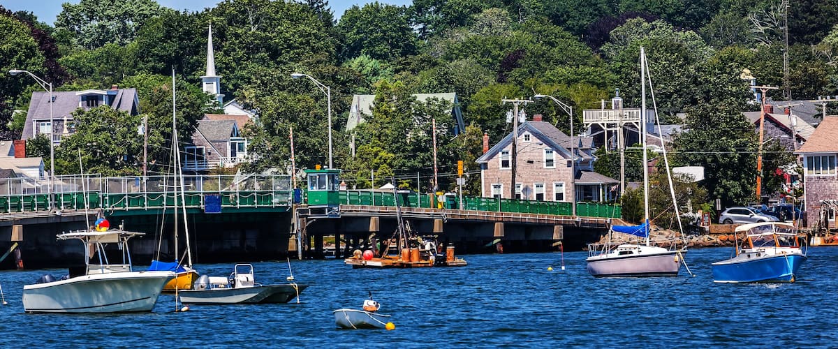 A harbor with boats, a bridge, and houses along the waterfront.