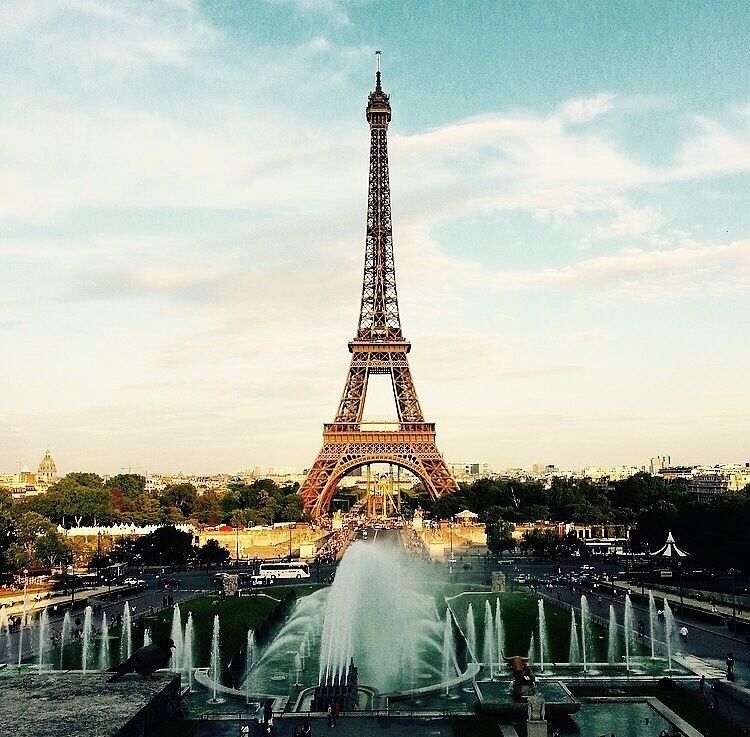 The Eiffel Tower with a fountain in the foreground.