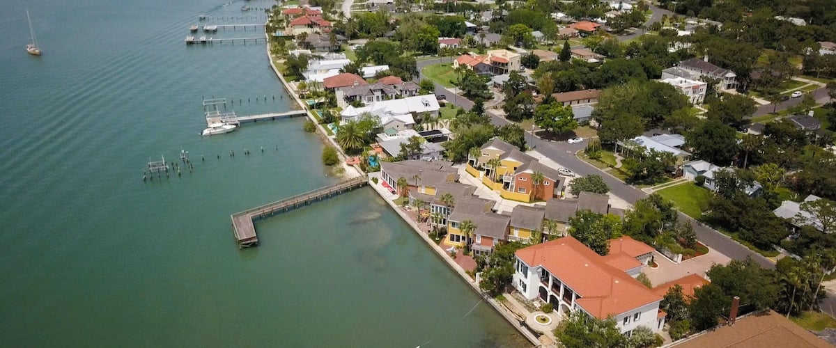 A coastal residential area with houses, a marina, and a bridge.
