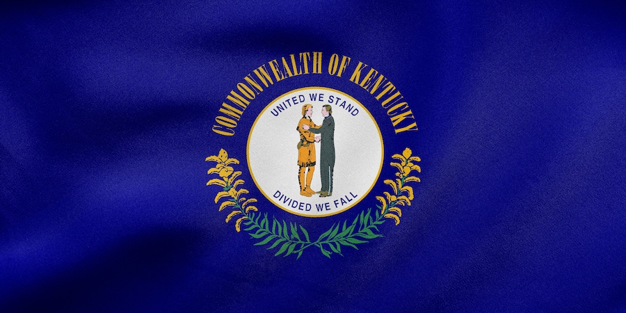 A flag with a circular emblem featuring two figures, surrounded by text and decorative elements.