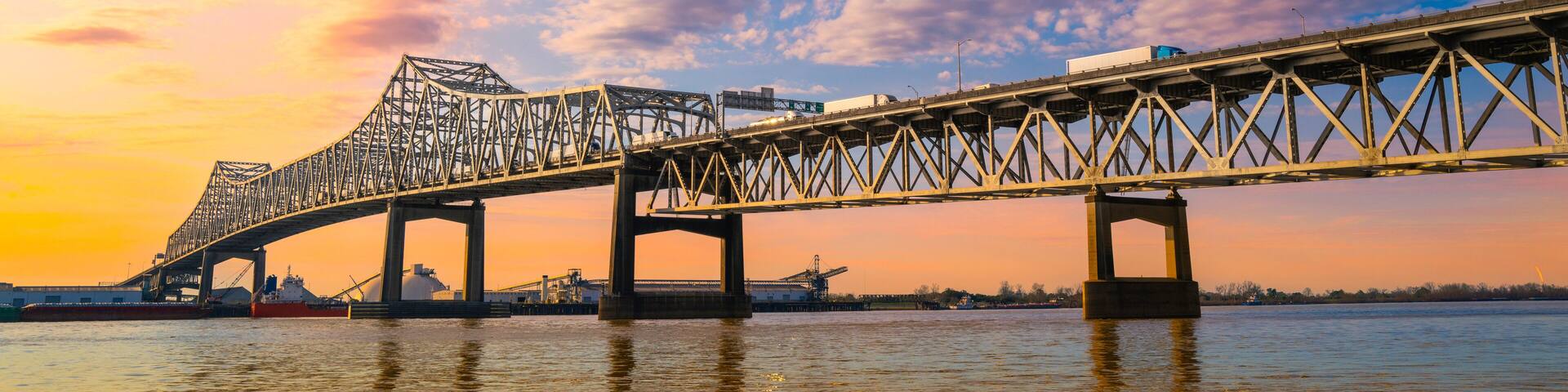 The Horace Wilkinson Bridge and Mississippi River at sunset with warm glowing clouds on the blue sky in Baton Rouge, Louisiana, USA