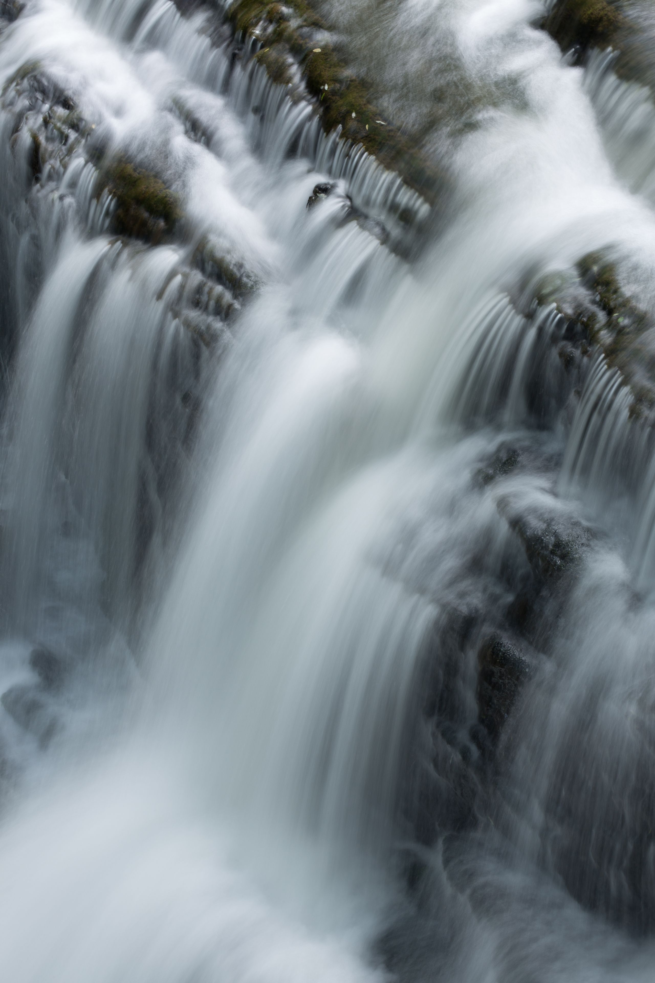 Una cascada fluye sobre rocas.