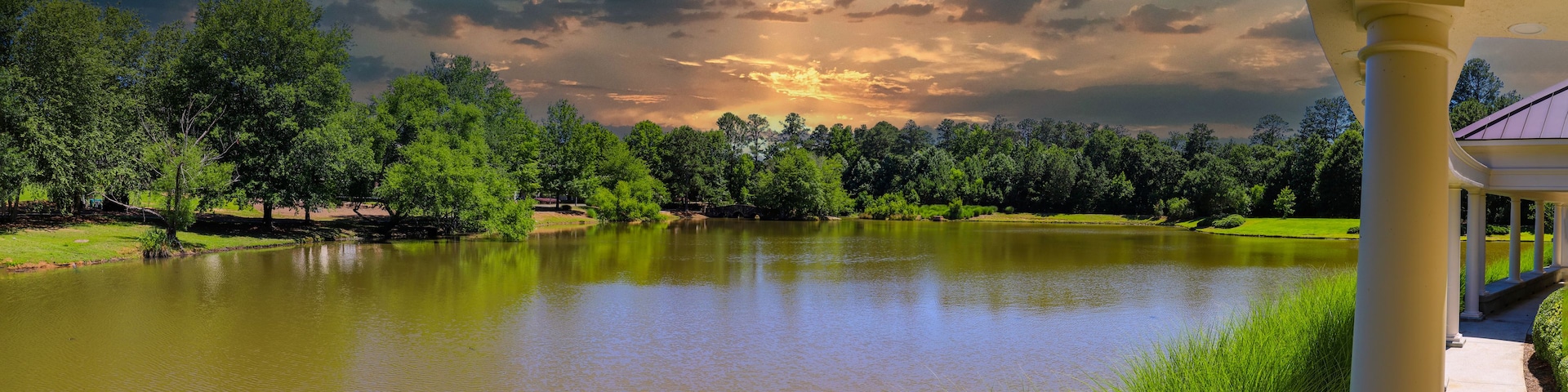 Un lac entouré d’arbres et un belvédère.
