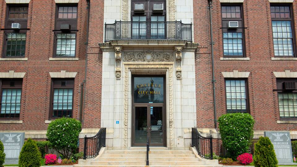 The entrance to Chelsea City Hall with a brick facade, decorative columns, and a central entrance.