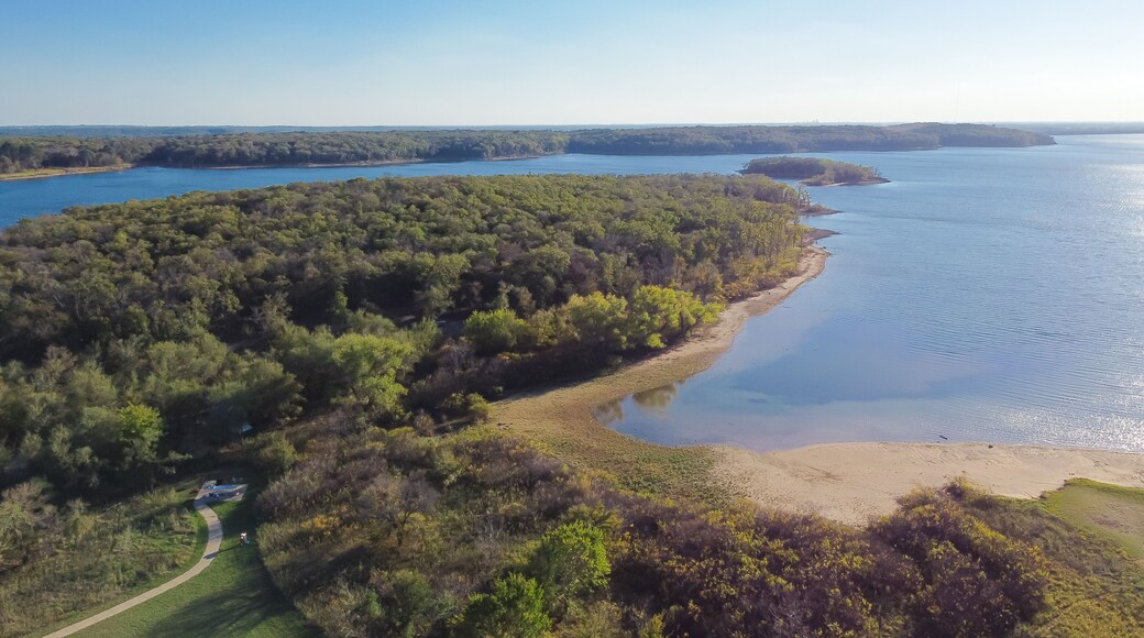 Aerial view a secondary point or hump surrounding by lush green trees and curved sandy shoreline at Isle du Bois Ray Roberts Lake State Park, remote primitive camping sites