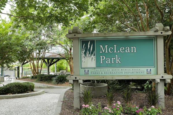 Placa de McLean Park, com área de piquenique e árvores ao fundo.