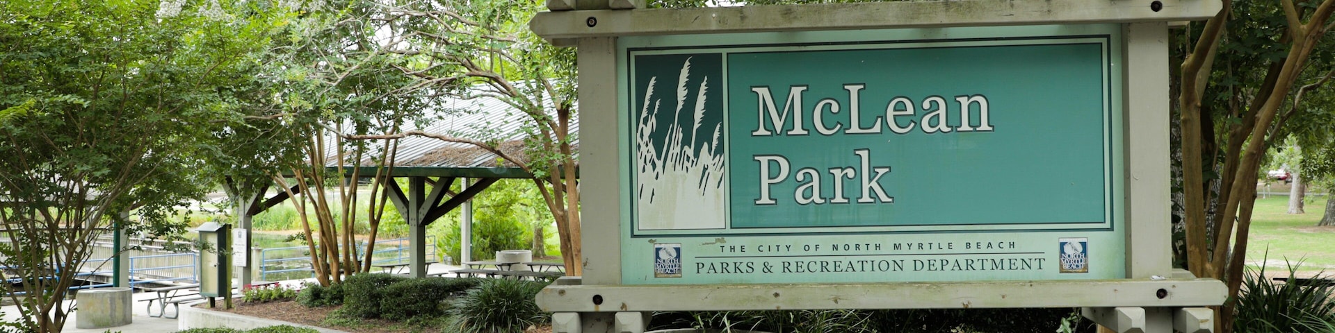 Placa de McLean Park, com área de piquenique e árvores ao fundo.