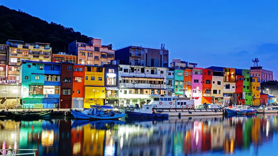 A waterfront with colorful buildings and boats.