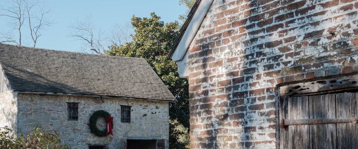 A stone building with a wooden door and a brick wall.