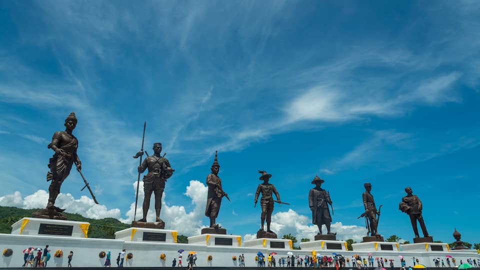 Una serie de estatuas sobre pedestales bajo un cielo azul despejado.