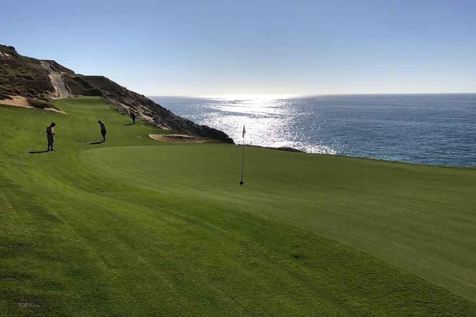 Um campo de golfe com vista para o oceano.