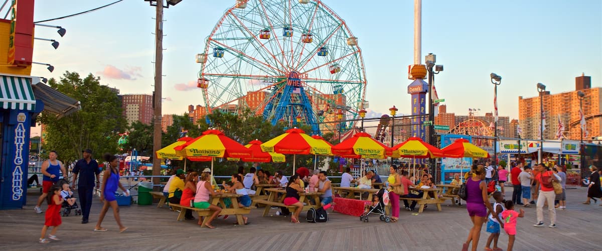 Riegelmann Boardwalk which includes a sunset and outdoor eating as well as a small group of people