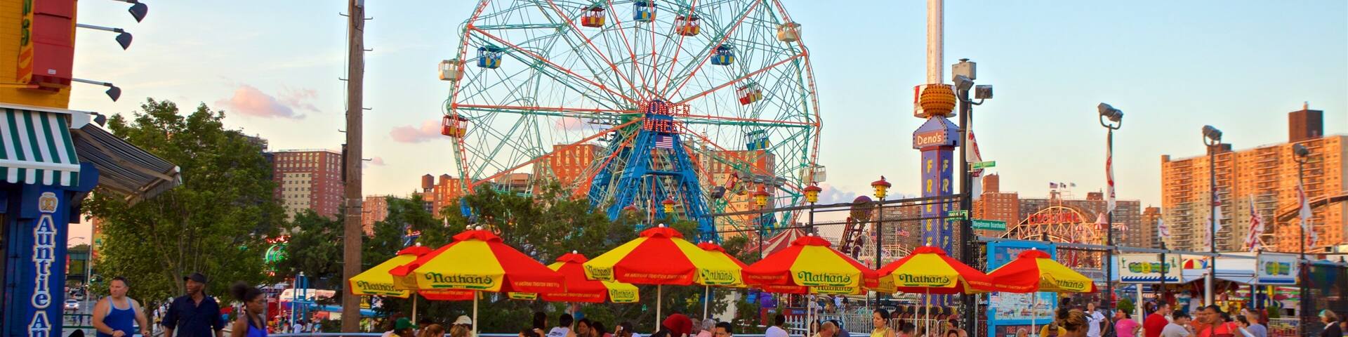 Riegelmann Boardwalk which includes a sunset and outdoor eating as well as a small group of people