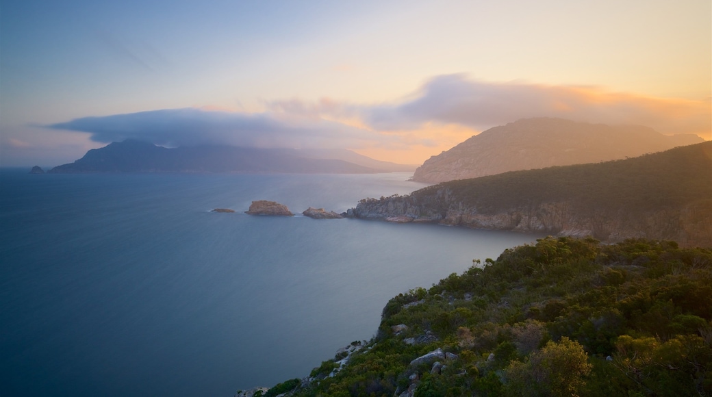 Coles Bay mostrando litoral rochoso, paisagens litorĂąneas e um pĂŽr do sol