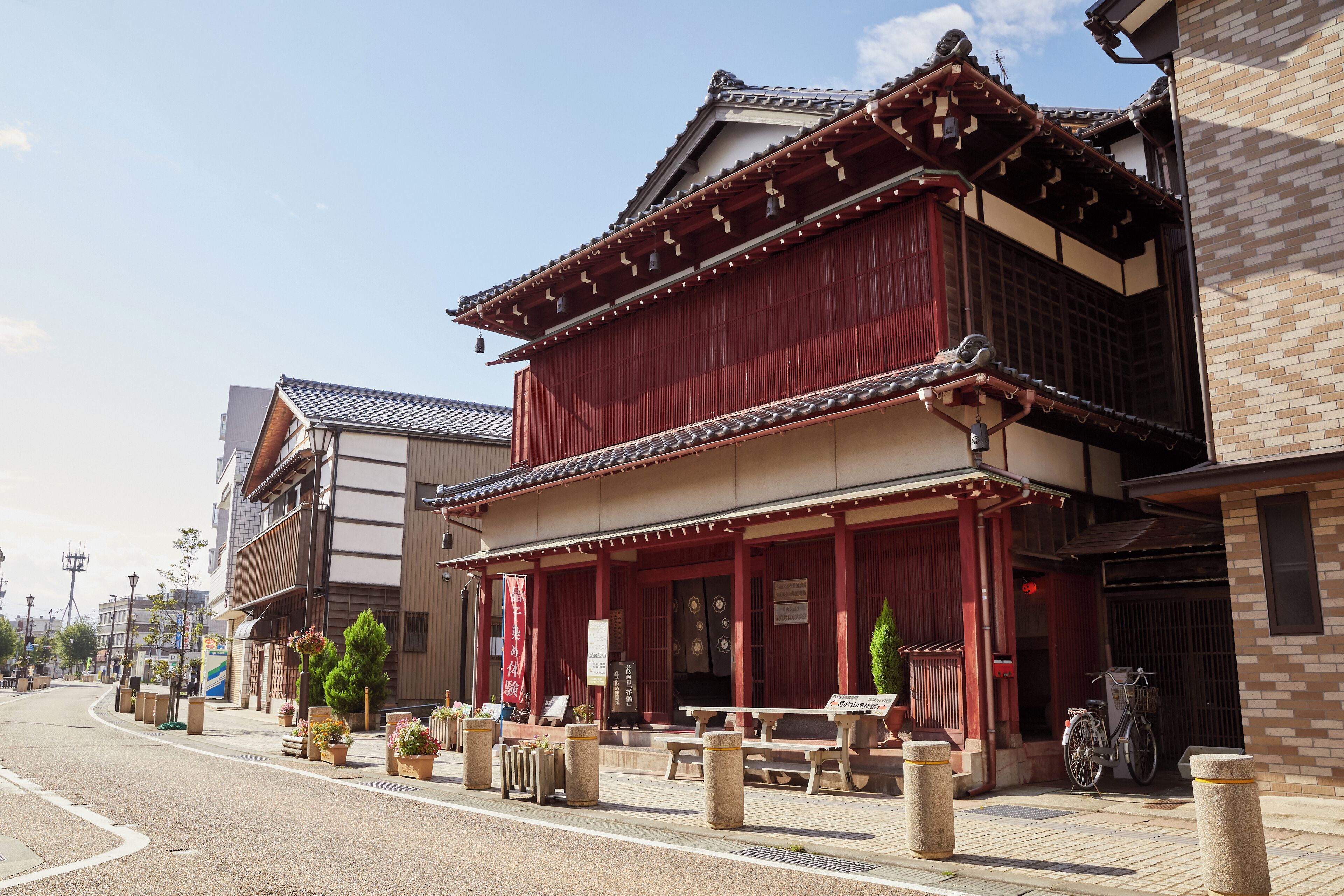 A traditional Japanese building with a red facade, wooden beams, and a tiled roof.