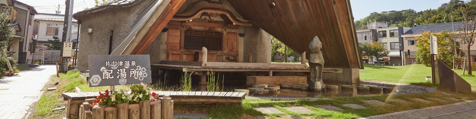 A traditional Japanese building with a slanted roof and a sign in front.