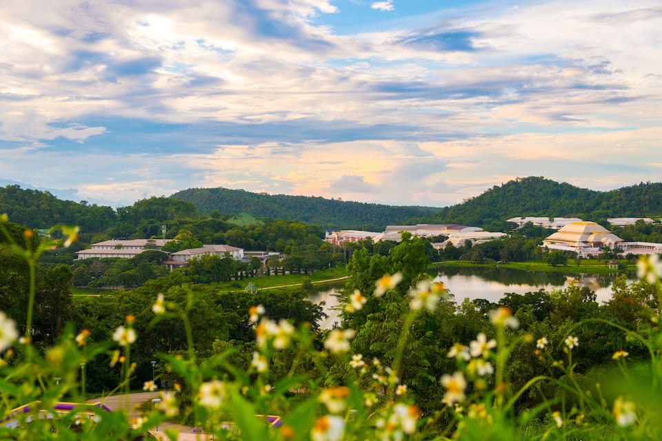 A lake surrounded by green hills and buildings.