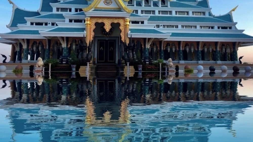 A traditional Thai building with a reflection in the water.
