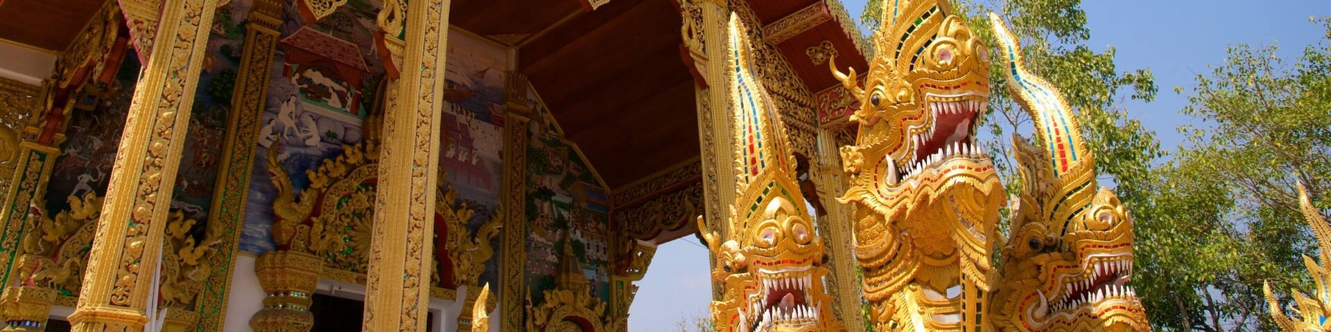Un templo dorado y ornamentado con tallas intrincadas y la figura de un dragón.