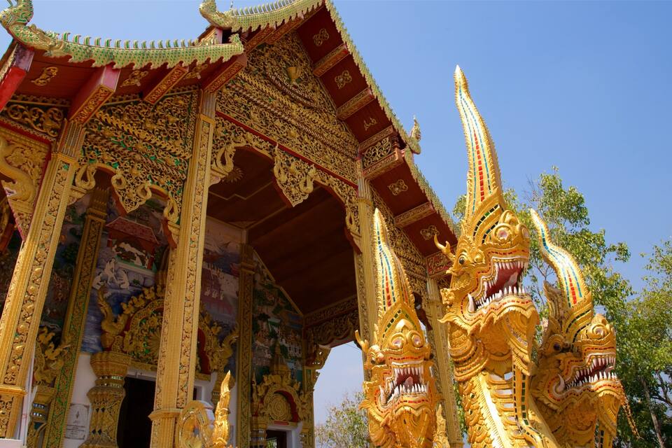 Um templo dourado e ornamentado, com esculturas detalhadas e a figura de um dragão.