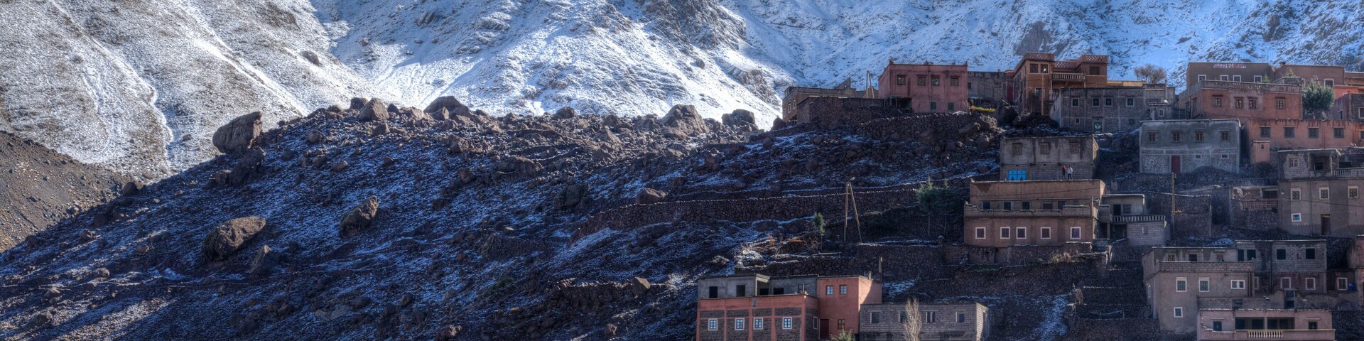 Una montaña nevada con un pueblo construido en sus laderas.
