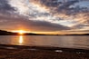 Warm orange sunset with cloudy sky viewed from the shore of Patoka Lake in Indiana