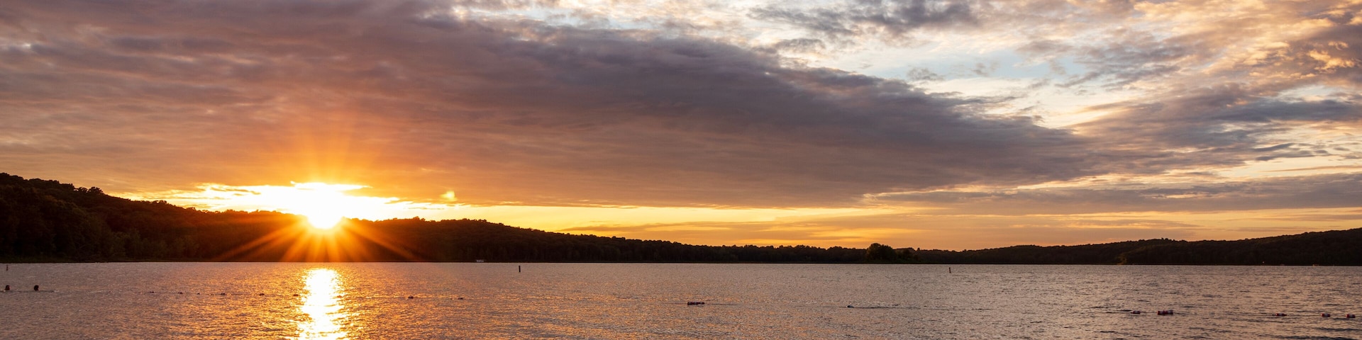 Warm orange sunset with cloudy sky viewed from the shore of Patoka Lake in Indiana