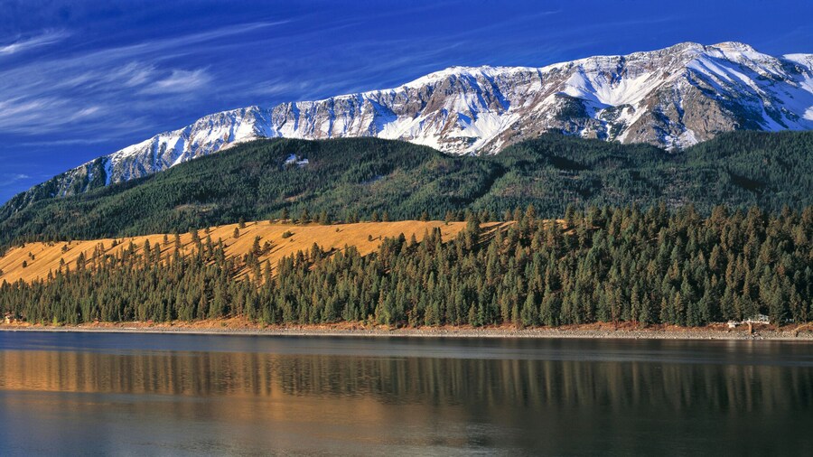 USA, Oregon, Wallowa Lake. Light snow covers the Wallowa Mountains in northeastern Oregon as autumn colors the grasses above Wallowa Lake.